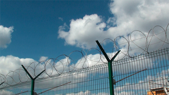 Secured Area With a Tower, a Fence and Barbed Wire