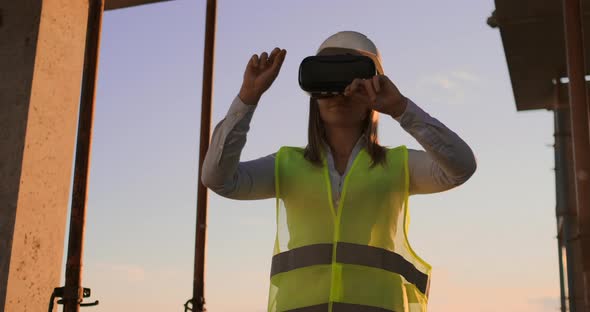 Female Engineer in Hardhat with VR Glasses Designing Construction Project at Manufacturing Plant