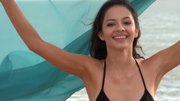 Happy Woman Running At The Beach Holding A Scarf alt