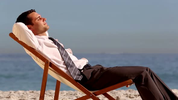 Smiling Businessman Relaxing On The Beach alt