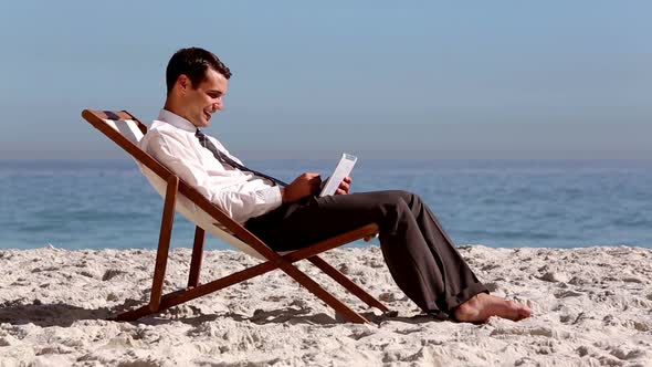 Smiling Businessman Using Tablet And Relaxing On The Beach