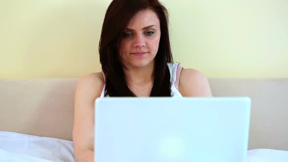 Woman Using Her Laptop In Her Bed alt