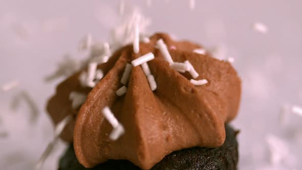 Pink Sprinkles Falling Onto Chocolate Cupcake