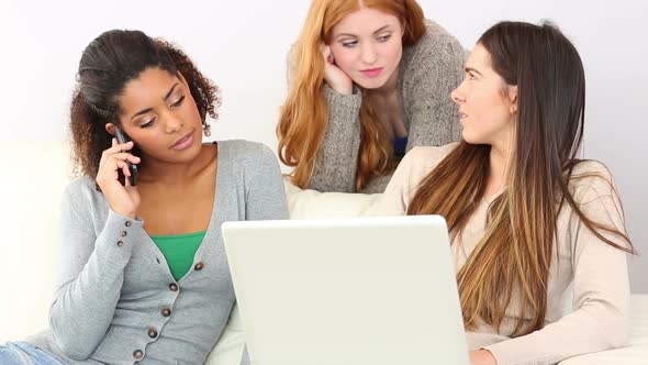 Cute Women Relaxing On Couch While Using Notebook And Smartphone