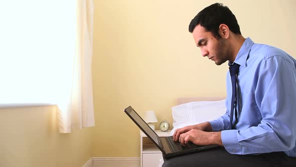 Portrait Of A Businessman Using His Laptop In Bed