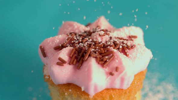 Icing Sugar Being Sieved On Pink Frosted Cupcake alt
