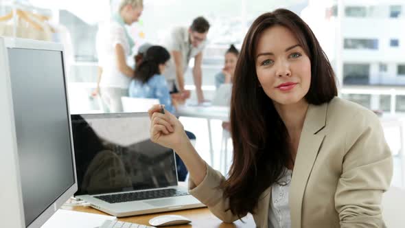 Woman Working At Her Desk And Smiling At Camera