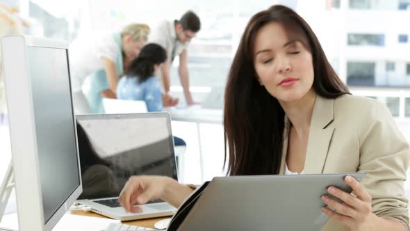 Woman Working At Her Desk Looking At Folder