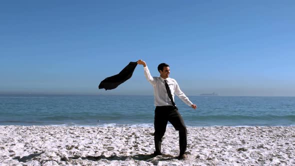 Businessman Undressing Then Throwing His Jacket On The Beach