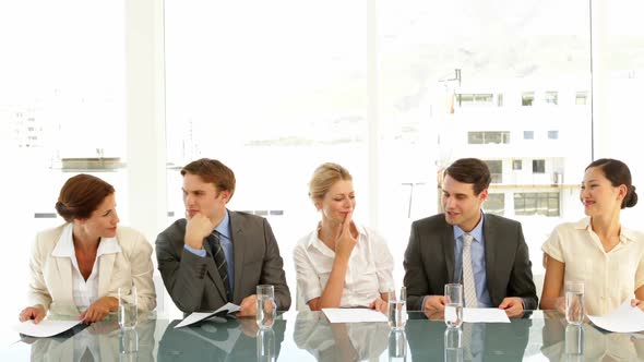 Interview Panel Holding Up Marks And Smiling