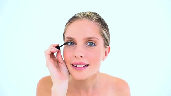Blond Woman Making Up Her Eye With Mascara alt