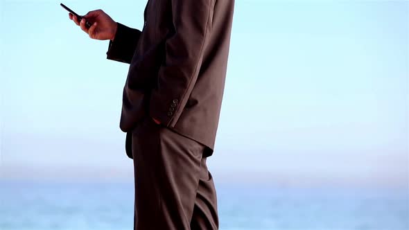 Unstressed Businessman Throwing His Phone On The Beach