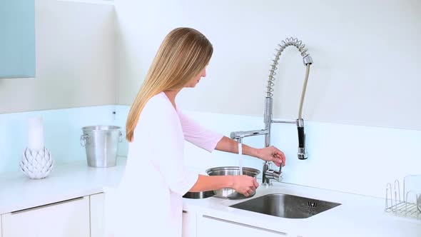 Blonde Woman Filling Water On Saucepan alt