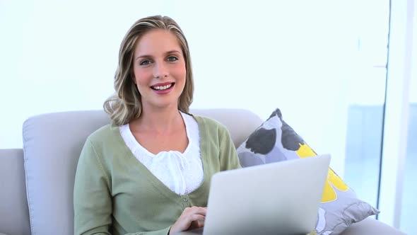 Smiling Woman Using Laptop On Couch