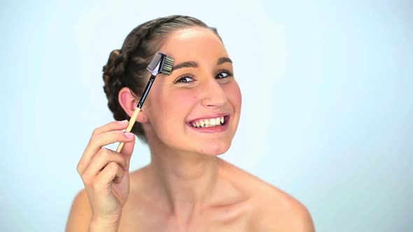 Smiling Young Woman Brushing Her Eyebrow