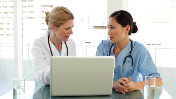 Doctor And Nurse Going Over A File On The Laptop alt
