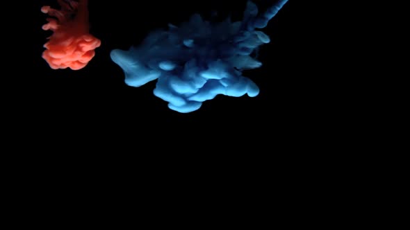 Blue And Red Paint Dropping In Water On Black Background