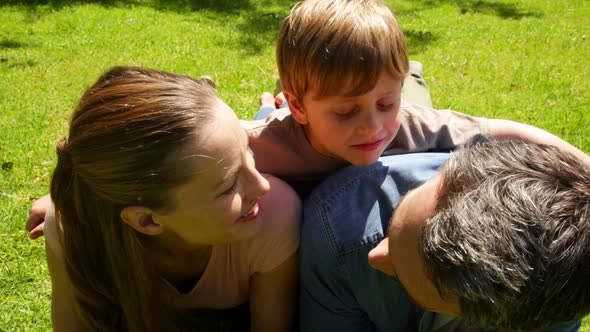 Little Boy And Parents Smiling At Camera In The Park While Little Boy Makes Funny Faces