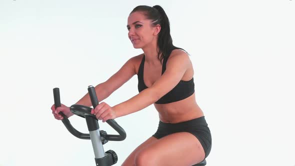 Sporty Cheerful Brunette Using Exercise Bike