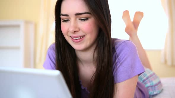 Pretty Woman Using A Tablet On Bed