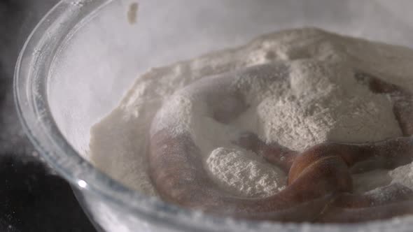 Pretzel Falling Into Bowl Of Flour