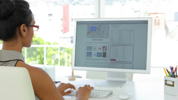 Cheerful Businesswoman Working At Her Desk alt