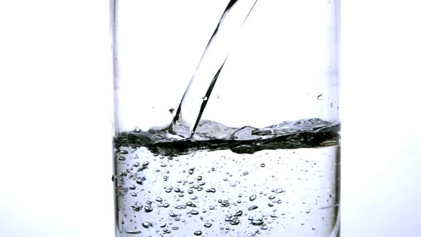 Water Being Poured Into A Glass On White Background alt