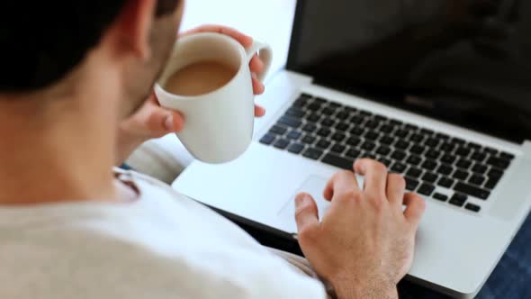 Man Drinking A Coffee While Using His Laptop