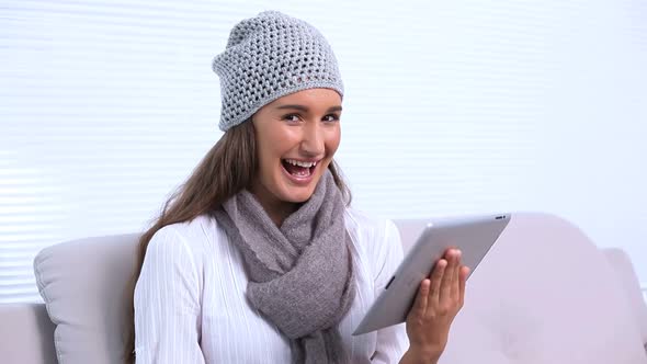 Brunette Sitting On Sofa Using Her Tablet Pc alt