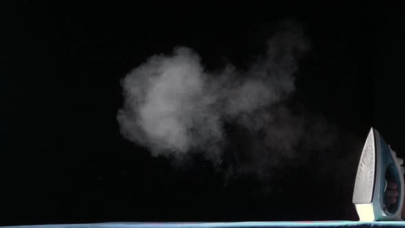 Steam Coming Out Of An Iron On Black Background
