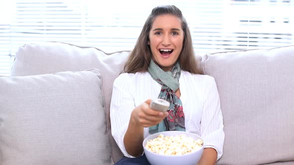 Brunette Watching Television And Eating Popcorn
