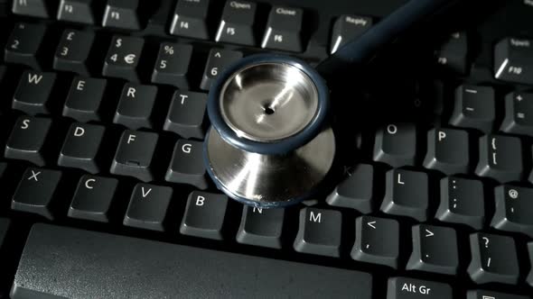 Stethoscope Falling Onto Computer Keyboard And Bouncing alt