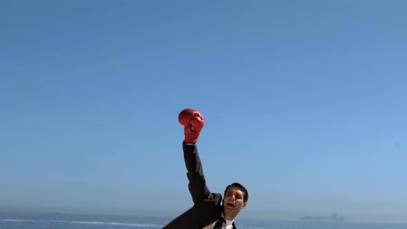 Attractive Businessman Jumping With Red Boxing Gloves