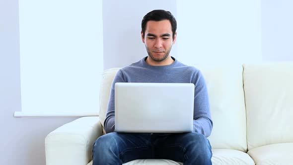 Man Using A Laptop On The Couch