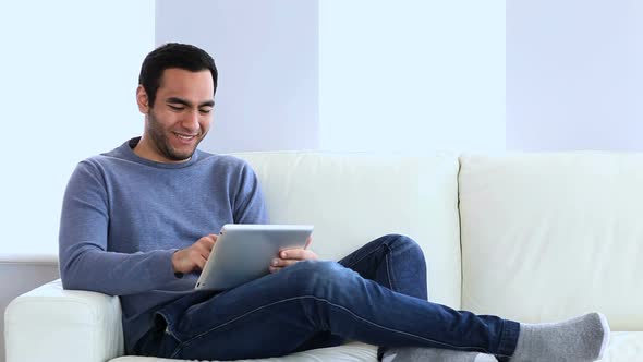 Man Using A Tablet On The Couch 1