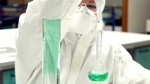 Science Student In Protective Suit Working With Green Chemicals alt