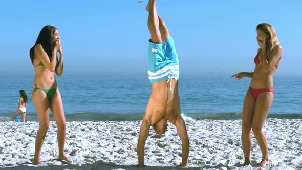 Man Walking On Hands Between Two Pretty Friends alt