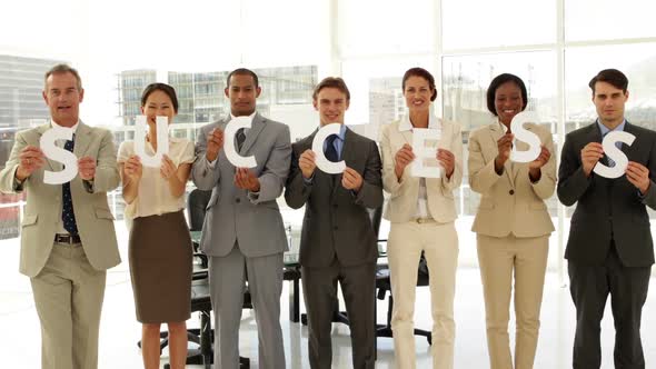 Business People Holding Letters Spelling Success alt