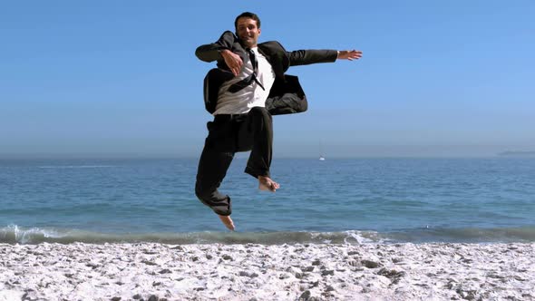 Handsome Businessman Jumping And Kicking On The Beach alt