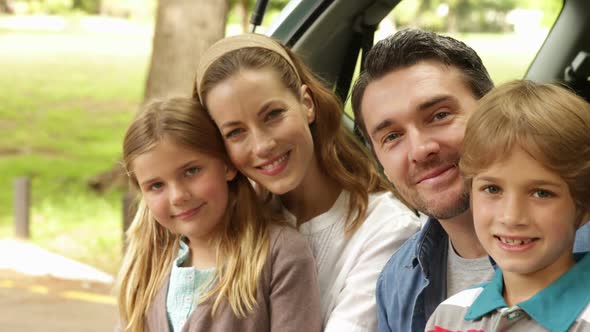 Family Smiling At Camera Together In The Park