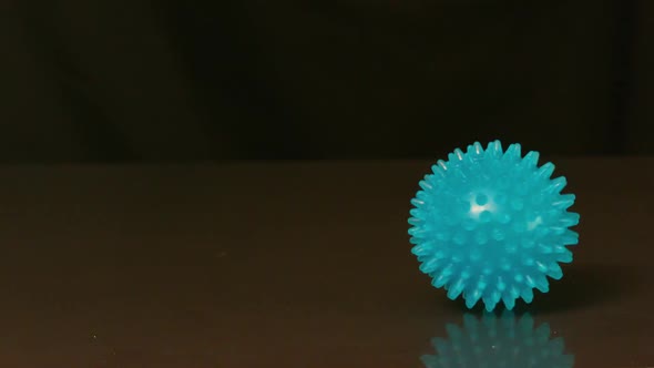 Massage Ball Spinning Across Black Surface