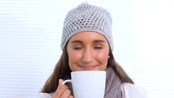 Young Woman With Hat And Scarf Smelling Her Cup