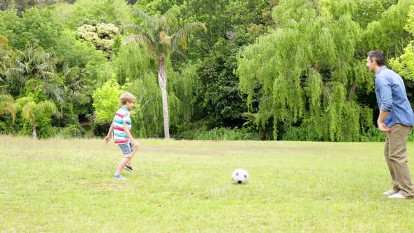Father And Son Kicking A Football