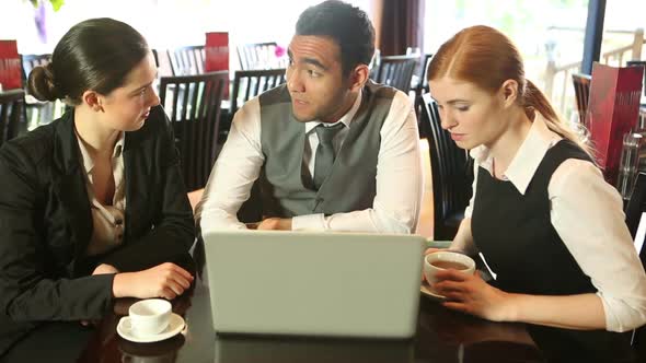 Colleagues Working Together While Having Coffee In A Restaurant