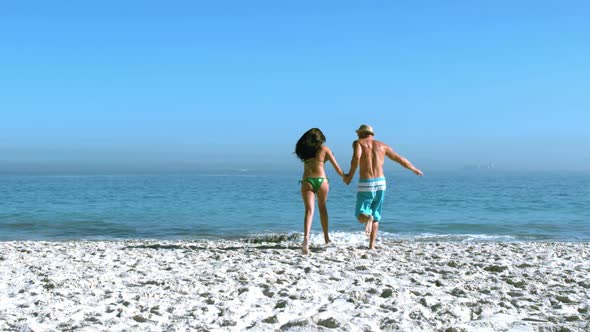 Handsome Man Running With His Friend Toward The Sea alt