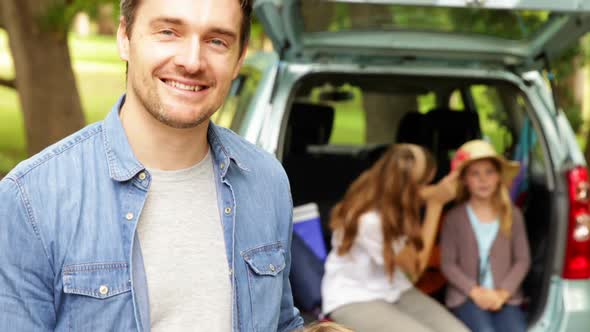 Father And Son Smiling At Camera In Front Of Car