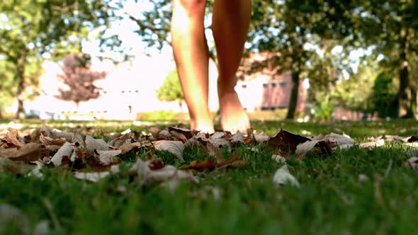 Female Feet Walking On Leaves