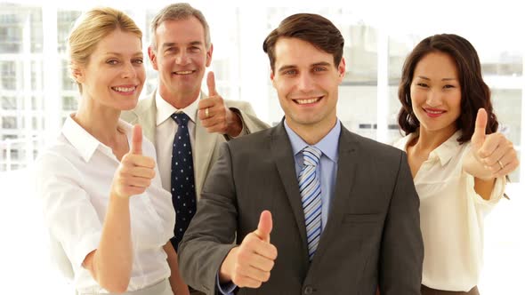 Business Team Giving Thumbs Up To Camera