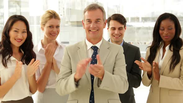 Business Team Smiling At Camera And Clapping