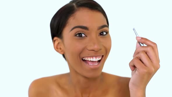 Woman Plucking Eyebrow With Tweezers